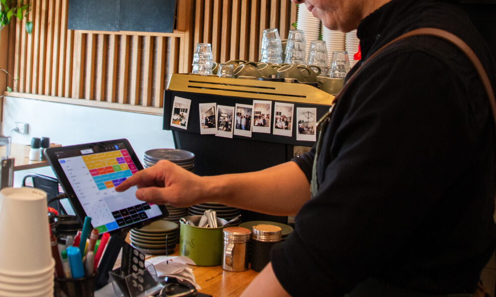 Put through a coffee order on the POS at a cafe
