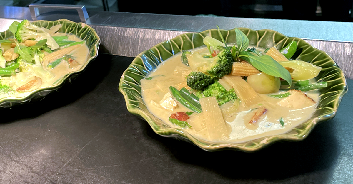 Vegetable Thai curry sitting on the pass in restaurant