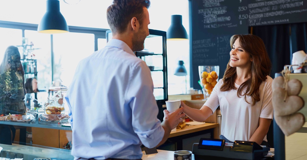 customer being handed a coffee in a cafe