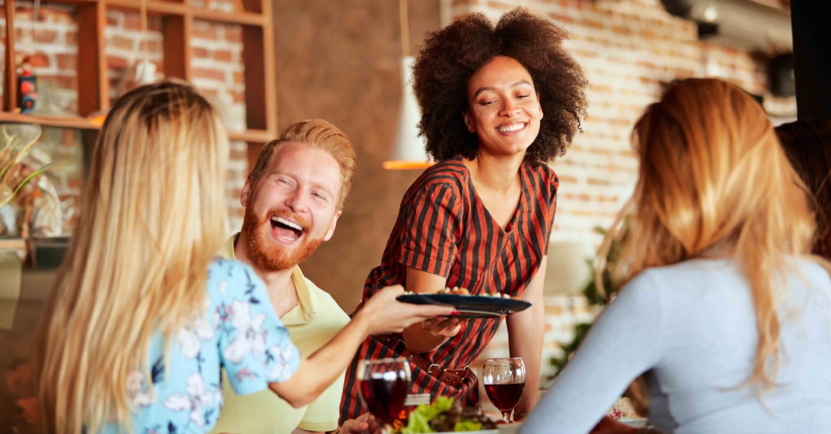 A group of friends enjoying food and drink in a hospitality venue